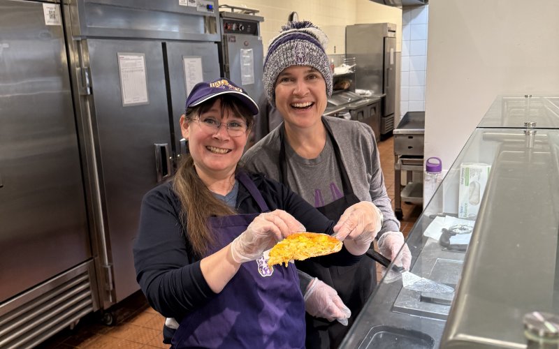 WCI Instructors Marcie Newton and Susan Detwiler serving pizza at fall 24' Food for Finals event. 