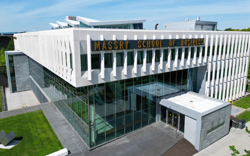 A building with multiple windows and a fully glass bottom, with the words Massry School of Business on it