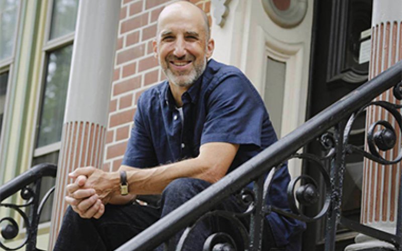 Edward Schwarzschild of the Department of English, director of creative writing and author of the new novel In Security, sits on the front stoop of his Center Square home in Downtown Albany. (Photo by Paul Buckowski/Albany Times Union)