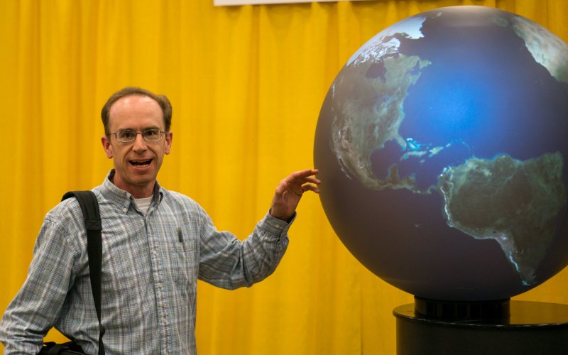 Professor Paul Roundy stands next to NASA headquarters at the American Meteorological Society annual meeting in Austin, Texas.