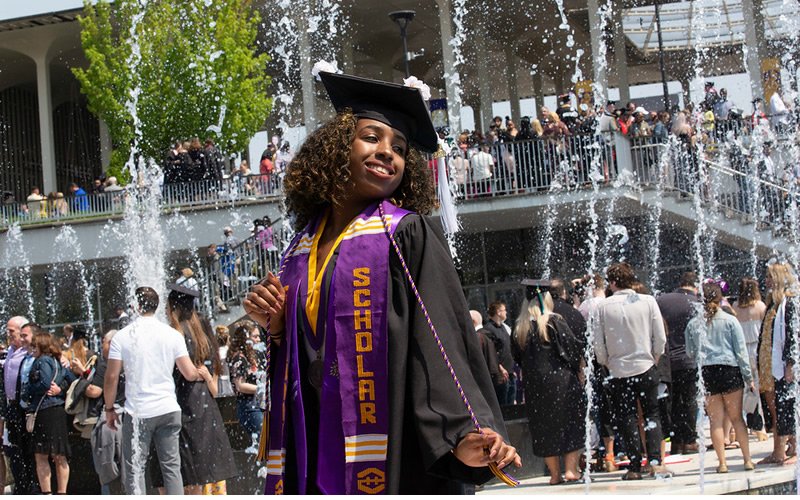 Students celebrating in their caps and gowns at commencement