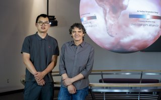 Postdoctoral research associate Zhiqiang Lyu and professor Mathias Vuille of the Department of Atmospheric and Environmental Sciences stand in front of a red and white air surface temperature change map inside the science-on-a-sphere room at ETEC.