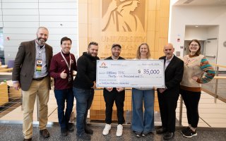 Representatives from CEHC and Wolfjaw stand with a $35,000 scholarship check inside the ETEC atrium.