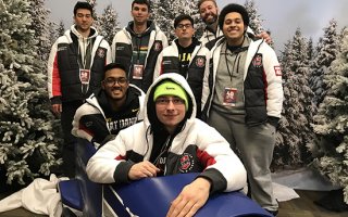 UAlbany’s “Overwatch” team takes photo with a bobsled at the Empire State Winter Games in Lake Placid.