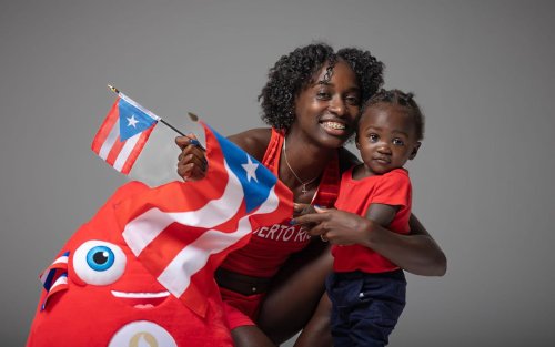 UAlbany alum Grace Claxton embraces her son, Thyree, while holding a Puerto Rican flag. Claxton is representing Puerto Rico at the 2024 Paris Olympics.