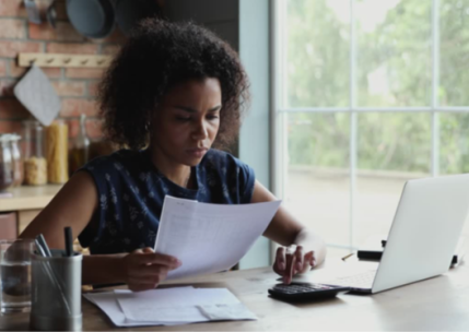 Black Woman doing accounting work at home desk