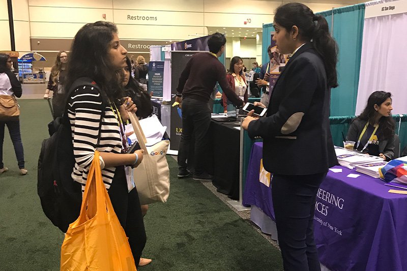 a person answering questions from a visitor at an expo