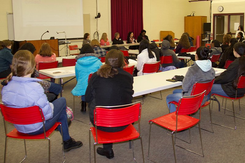 a group of people in front of a panel at a table