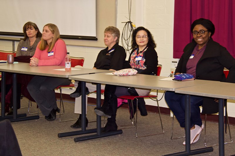 5 people sitting at a table ready to answer questions at a high school