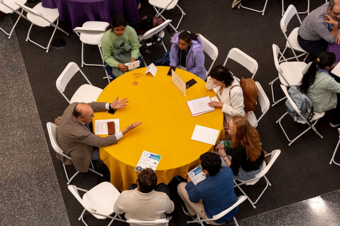 A group of participants discussing at a round table.