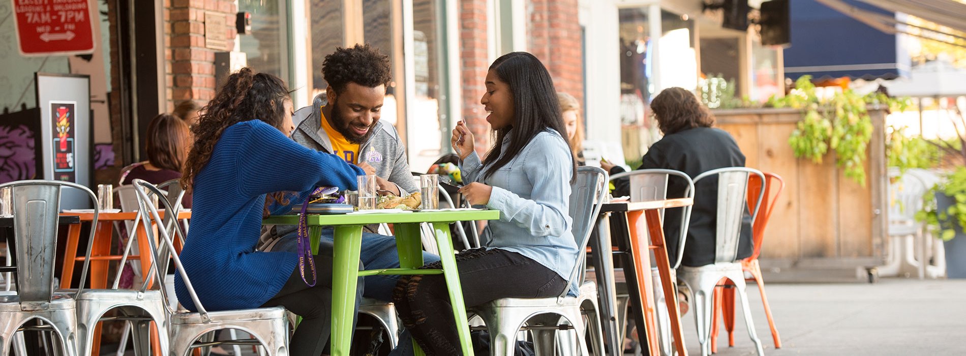 Three students eating together in downtown Albany