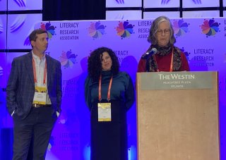 two people standing next to a person at the podium