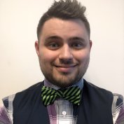 Dr. Scott Storm smiling wearing vest and bowtie with off-white background