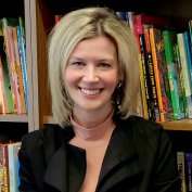 Dr. Lori Bruner smiling in front of a bookshelf