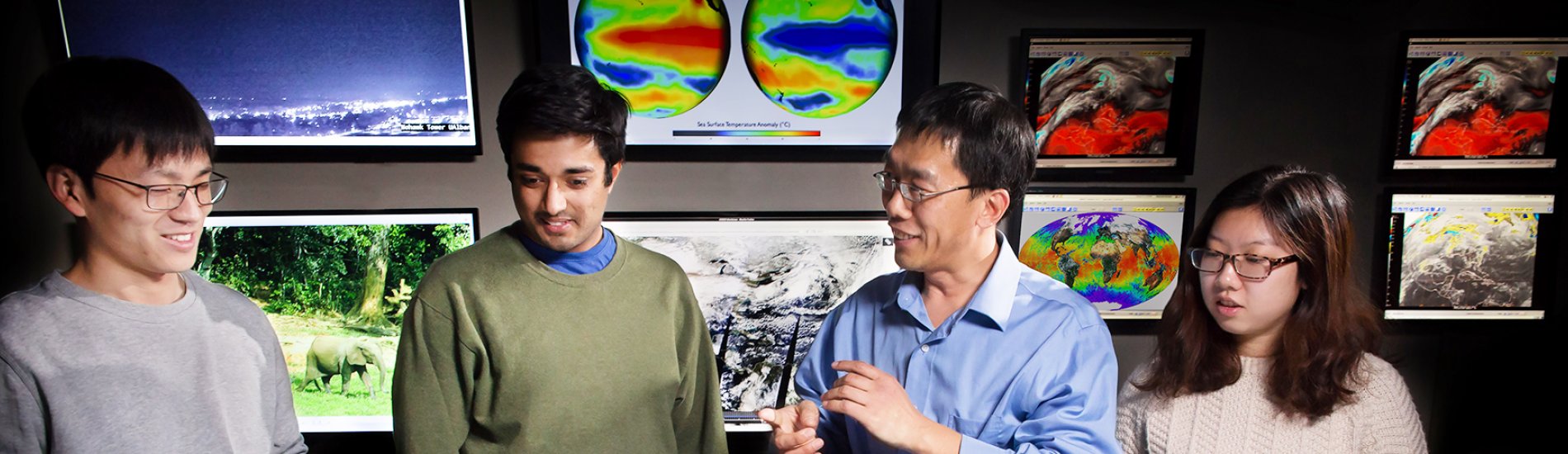 A UAlbany professor and students studying climate maps.