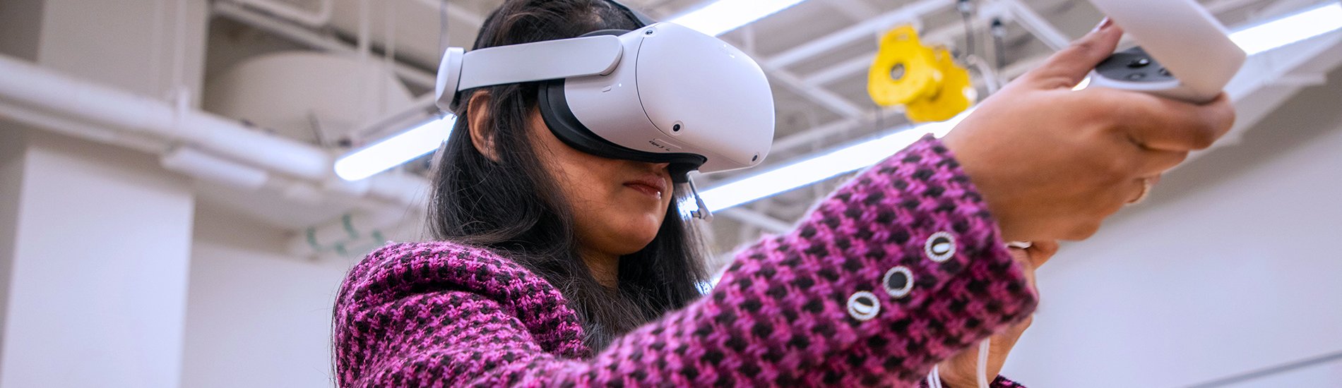 A student wearing virtual reality goggles and paddles.