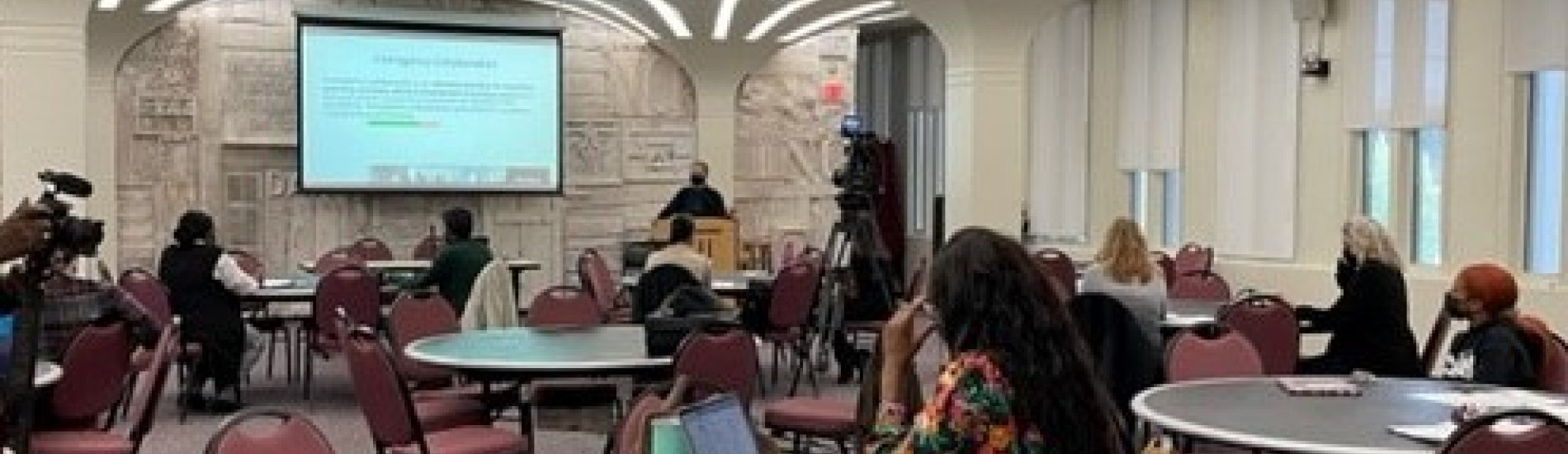 people at round tables watching a presentation at the Equity in Transition Summit