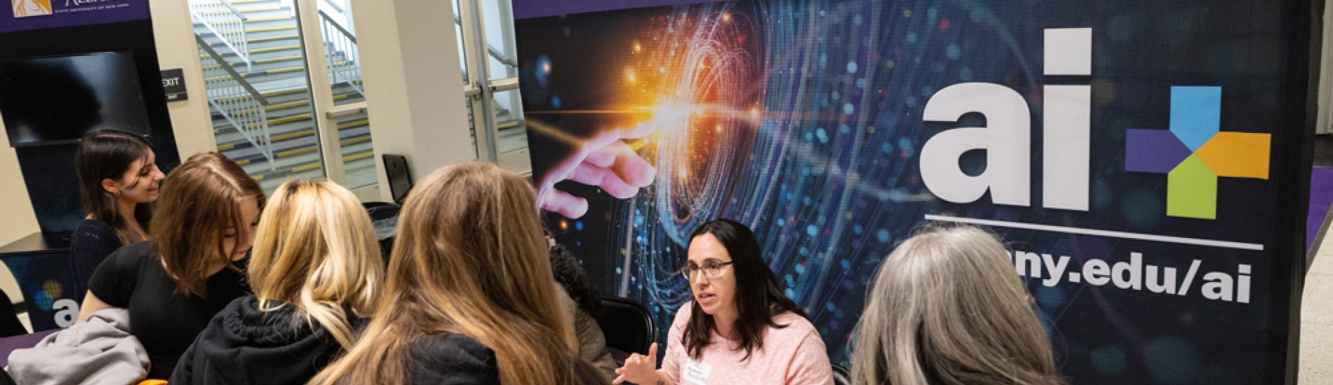 A group of students discussing AI Plus at UAlbany Showcase Day.