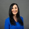 woman smiling for a professional headshot in a blue blouse