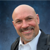 Man smiling with white button up shirt and black jacket